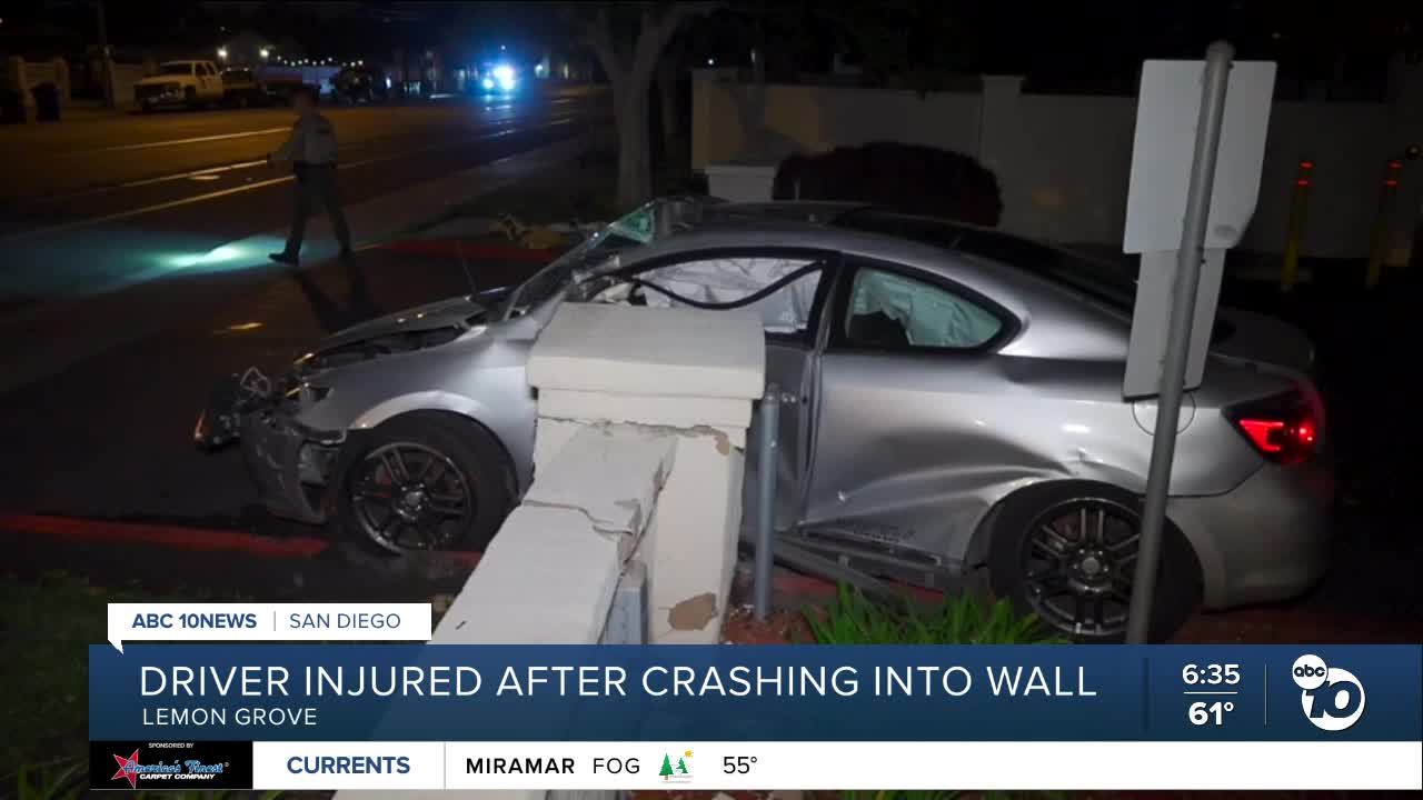 Trapped driver pulled from car after crashing into retaining wall in ...